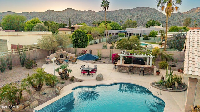 3733 E Kachina Dr, Phoenix, AZ 85044 - pool at dusk featuring a fenced backyard, a mountain view, and a patio area
