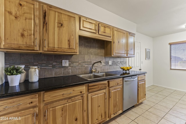 kitchen with stainless steel dishwasher, light tile patterned floors, sink, and tasteful backsplash