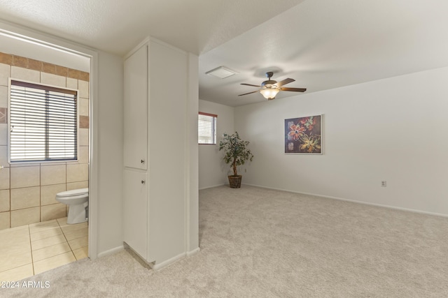 carpeted spare room featuring a textured ceiling, plenty of natural light, and ceiling fan