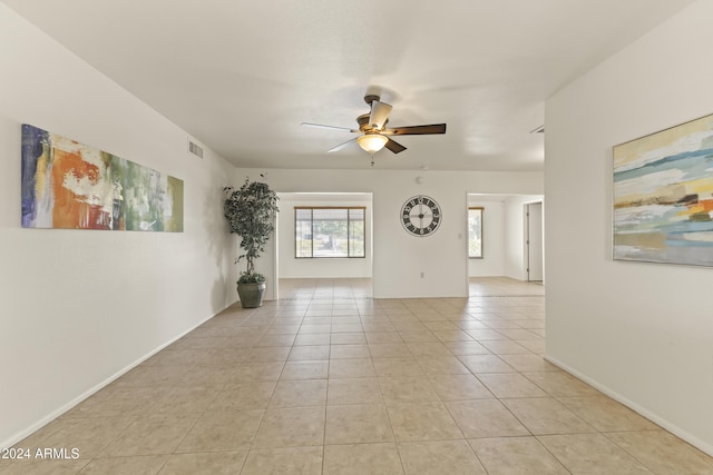 tiled empty room featuring ceiling fan