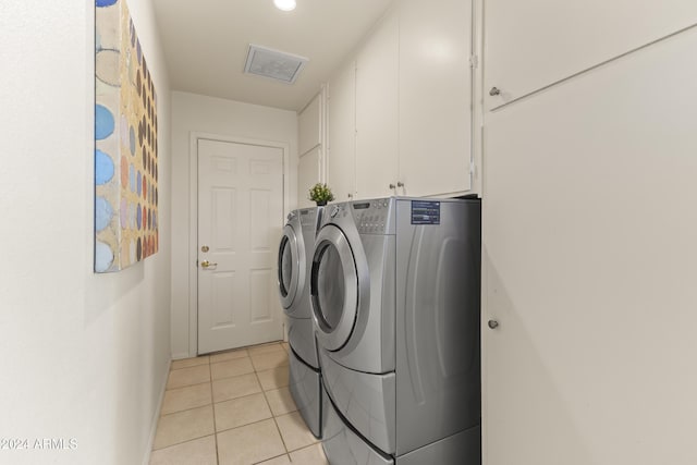 laundry room with cabinets, independent washer and dryer, and light tile patterned floors