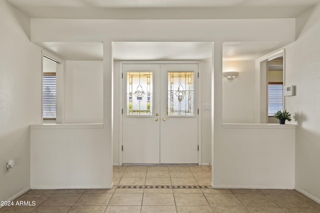 entrance foyer with light tile patterned flooring and french doors