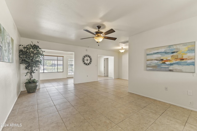 unfurnished room with light tile patterned floors and ceiling fan