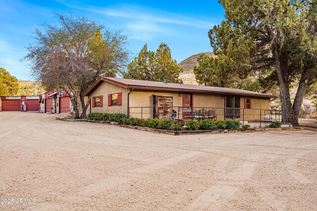 51238 N Pinal Ranch Rd, Miami, AZ 85539 - view of front of property featuring dirt driveway, an outdoor structure, a mountain view, and stucco siding