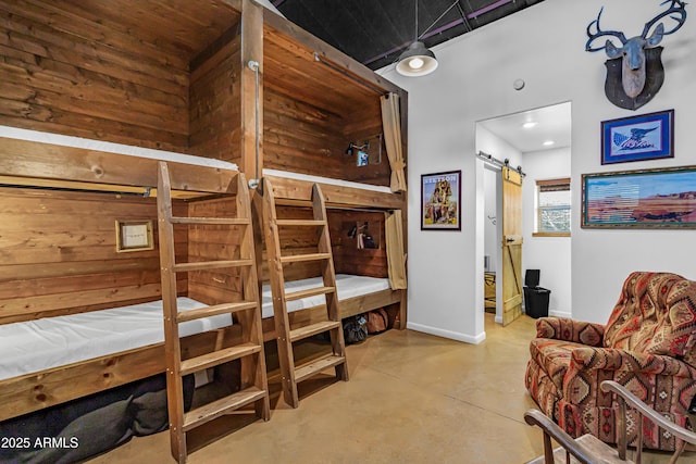 51238 N Pinal Ranch Rd, Miami, AZ 85539 - bedroom with baseboards, a barn door, and finished concrete floors