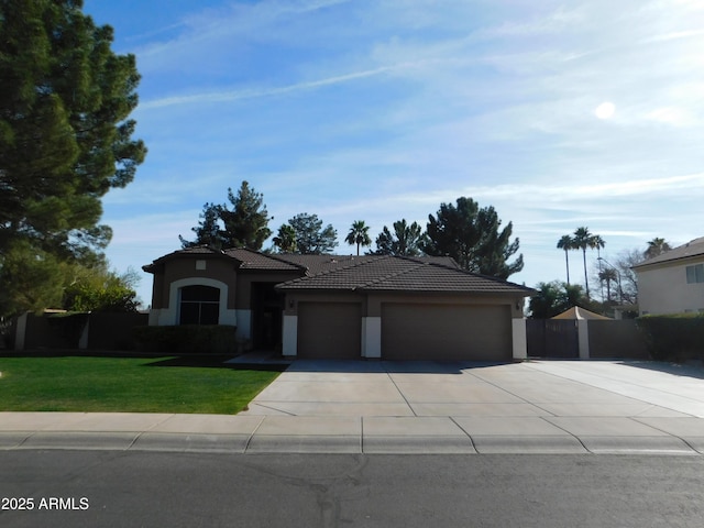 view of front facade with a garage, a tile roof, concrete driveway, stucco siding, and a front yard