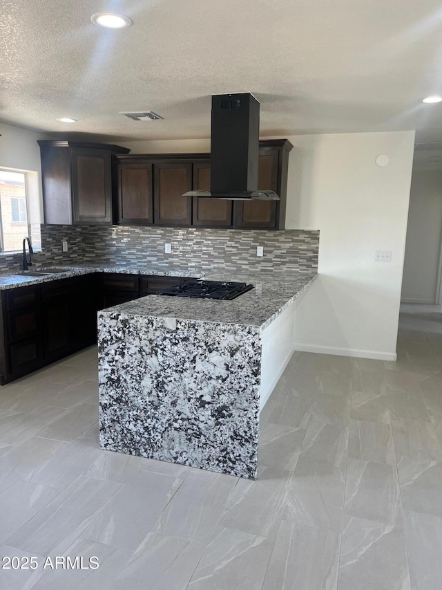 kitchen featuring black gas cooktop, sink, exhaust hood, light stone counters, and dark brown cabinets