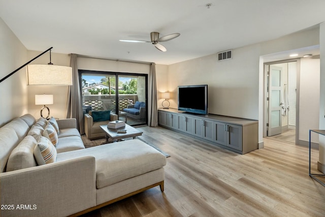 living area with light wood-style floors, a ceiling fan, and visible vents