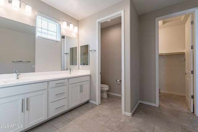 613 W Winchester Dr, Chandler, AZ 85286 - bathroom with double vanity, toilet, a spacious closet, and baseboards