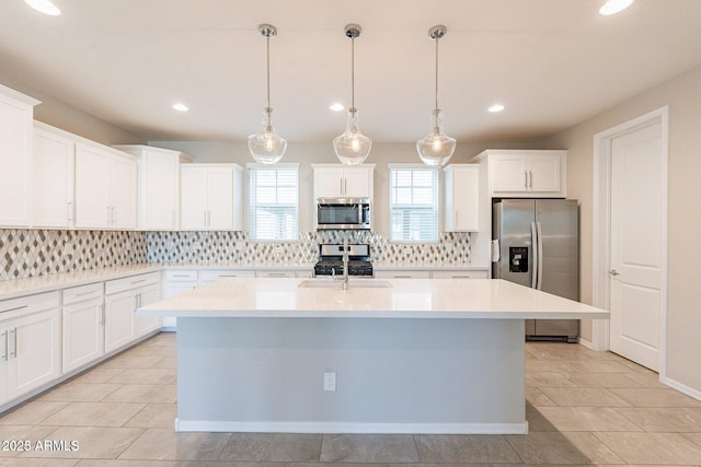 613 W Winchester Dr, Chandler, AZ 85286 - kitchen featuring stainless steel appliances, backsplash, a center island with sink, recessed lighting, and light countertops