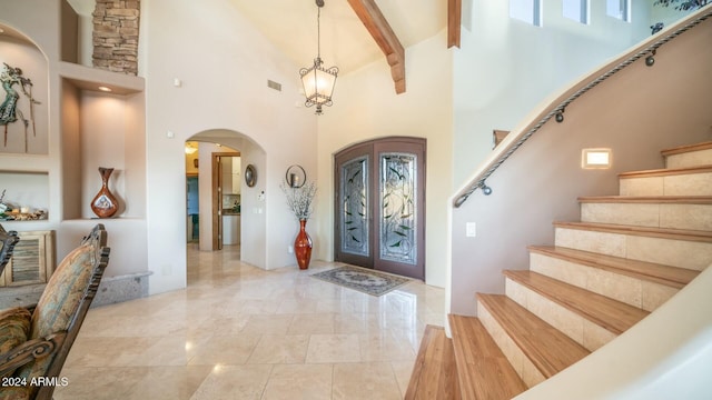 entryway with beamed ceiling and a towering ceiling