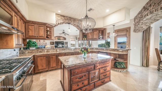 kitchen featuring kitchen peninsula, stainless steel range, a center island, and decorative light fixtures