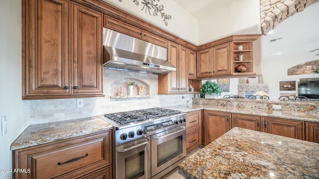 kitchen featuring light stone countertops, decorative backsplash, high end stove, and ventilation hood