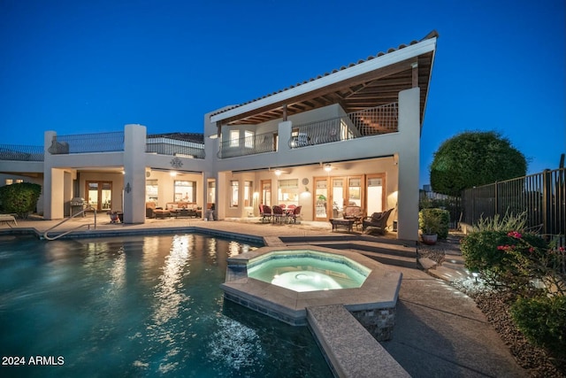 rear view of property with a patio area, ceiling fan, a balcony, and a pool with hot tub