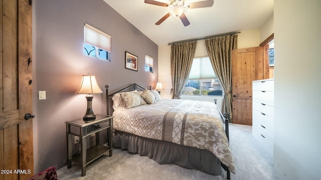 bedroom with multiple windows, light carpet, and ceiling fan