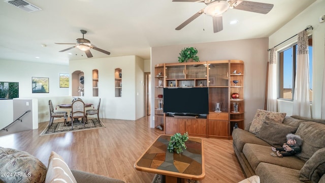 living room featuring plenty of natural light, ceiling fan, and light hardwood / wood-style flooring