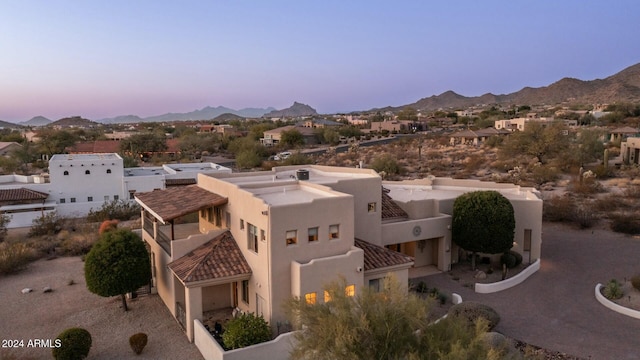 aerial view at dusk featuring a mountain view