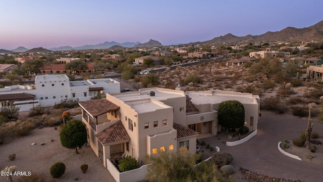 aerial view at dusk featuring a mountain view