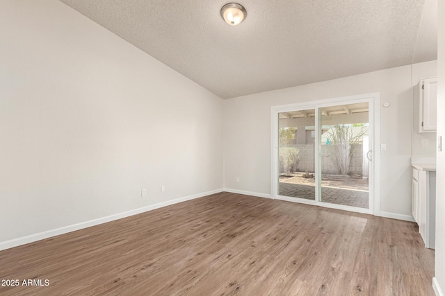 2318 N 87th Ave, Phoenix, AZ 85037 - unfurnished room featuring vaulted ceiling, a textured ceiling, and light wood finished floors