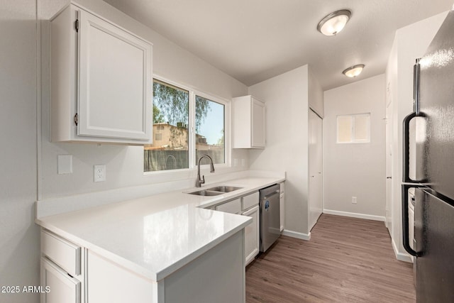 2318 N 87th Ave, Phoenix, AZ 85037 - kitchen featuring freestanding refrigerator, dishwasher, light wood-style flooring, light countertops, and white cabinets
