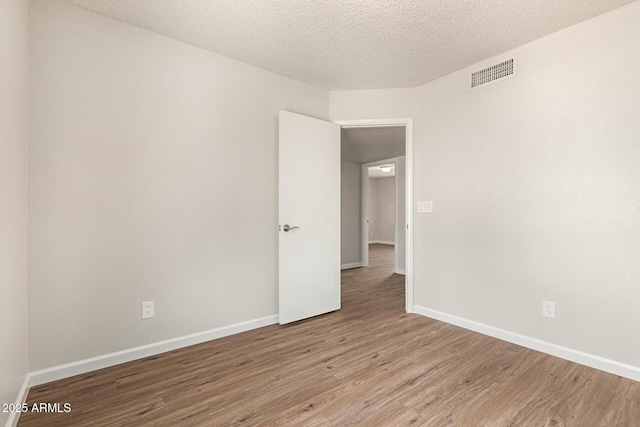2318 N 87th Ave, Phoenix, AZ 85037 - spare room featuring wood finished floors and a textured ceiling