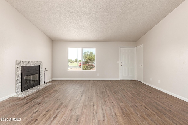 2318 N 87th Ave, Phoenix, AZ 85037 - unfurnished living room featuring wood finished floors, a fireplace, and a textured ceiling