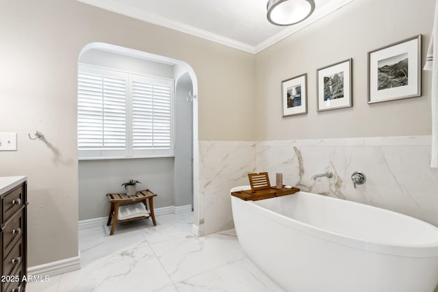 bathroom with vanity, ornamental molding, and a washtub