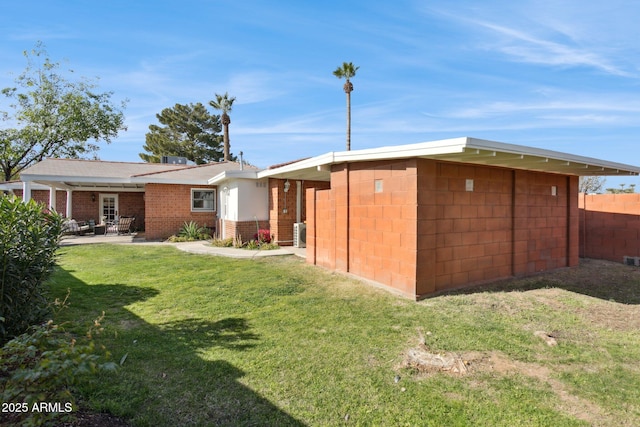 rear view of house with a patio area and a lawn