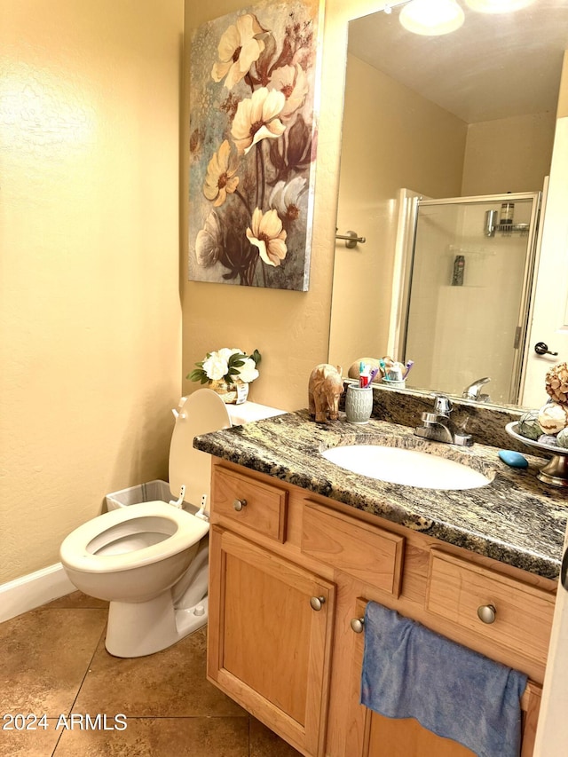 bathroom featuring vanity, toilet, tile patterned floors, and a shower with shower door