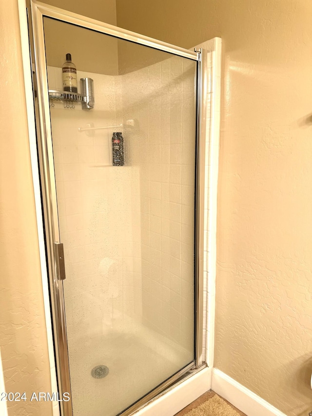 bathroom featuring a shower with shower door