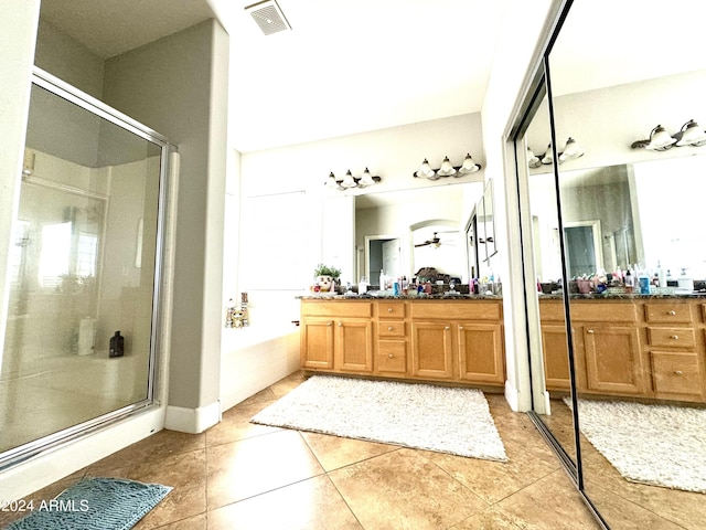 bathroom featuring tile patterned floors, vanity, and shower with separate bathtub