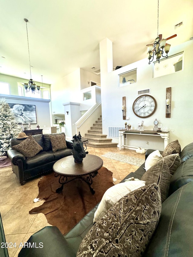 living room featuring light tile patterned flooring, a chandelier, and a high ceiling