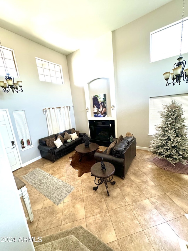 living room featuring an inviting chandelier, a high ceiling, and light tile patterned floors