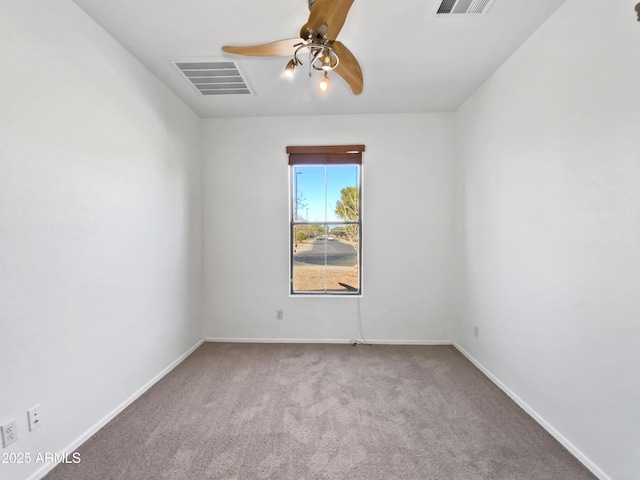 carpeted spare room featuring visible vents, baseboards, and ceiling fan