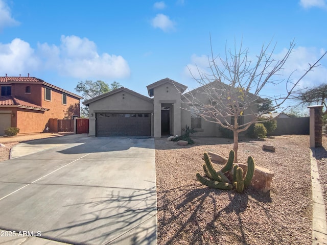 view of front of property featuring fence, a garage, driveway, and stucco siding