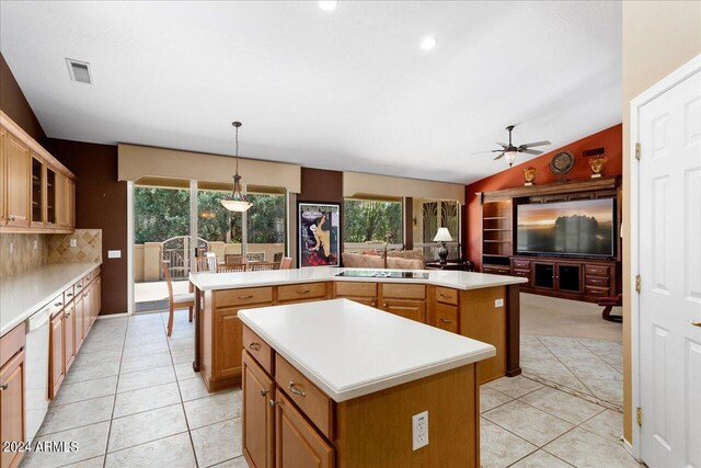 kitchen featuring a wealth of natural light, hanging light fixtures, vaulted ceiling, and a kitchen island