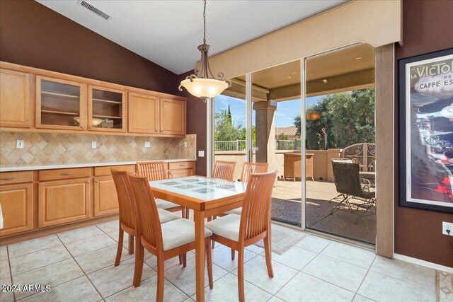 dining room featuring lofted ceiling and light tile patterned flooring