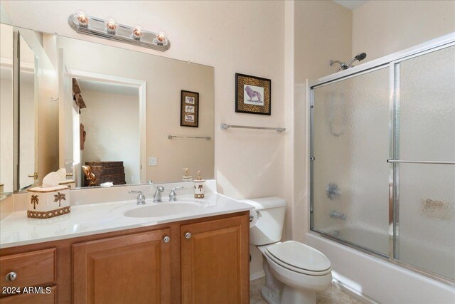 full bathroom featuring shower / bath combination with glass door, vanity, and toilet