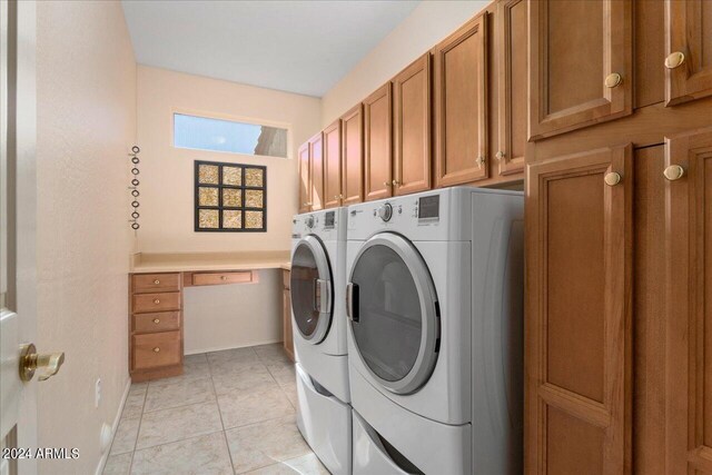 washroom featuring light tile patterned floors, washer and dryer, and cabinets