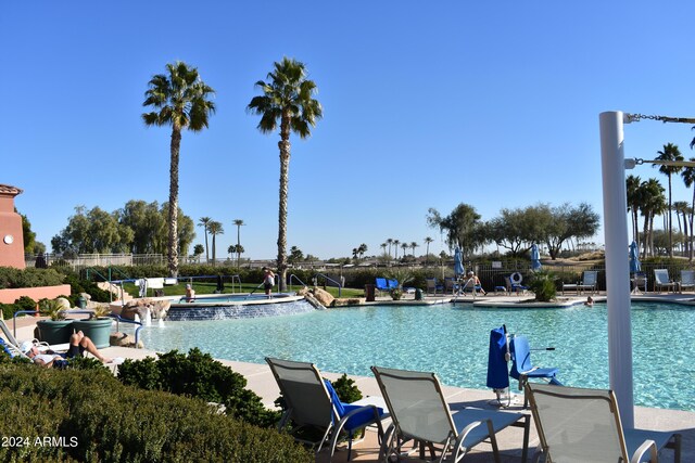 view of pool with a community hot tub, a patio, and pool water feature