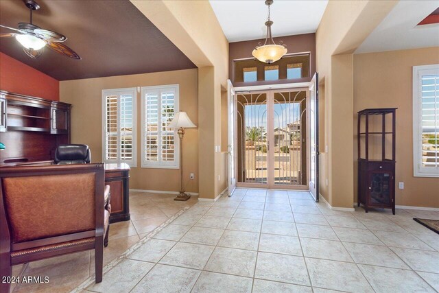 foyer entrance featuring ceiling fan, lofted ceiling, plenty of natural light, and light tile patterned floors