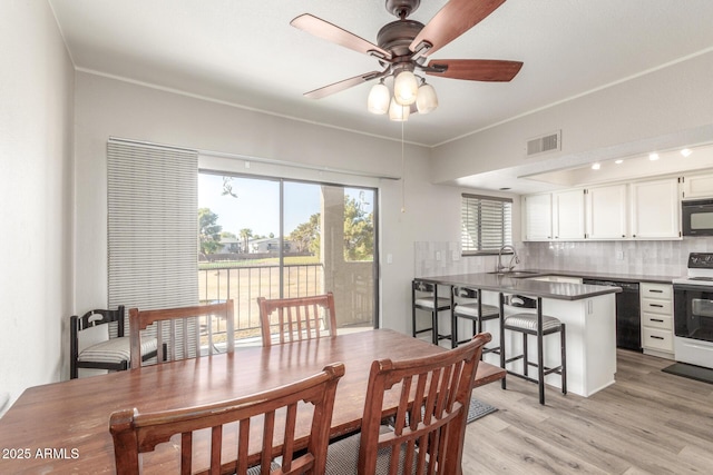 dining area with ceiling fan, sink, light hardwood / wood-style flooring, and crown molding