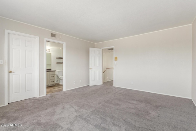 unfurnished bedroom featuring connected bathroom and light colored carpet