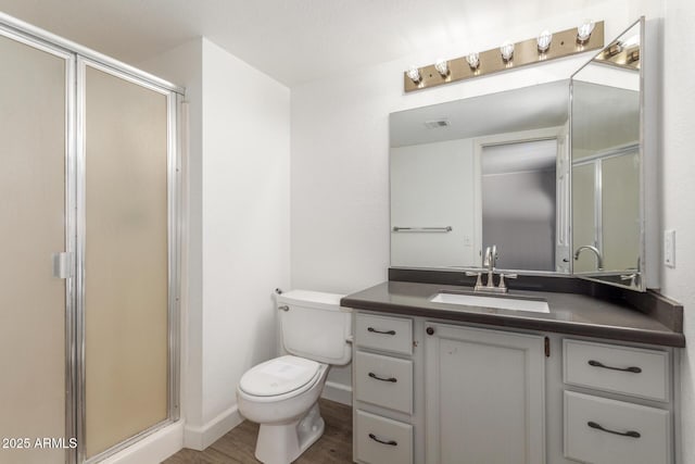 bathroom with a shower with shower door, vanity, toilet, and hardwood / wood-style flooring