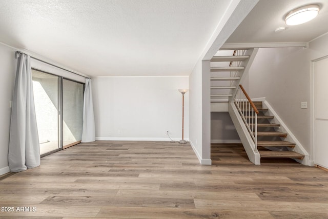 interior space featuring light wood-type flooring and a textured ceiling