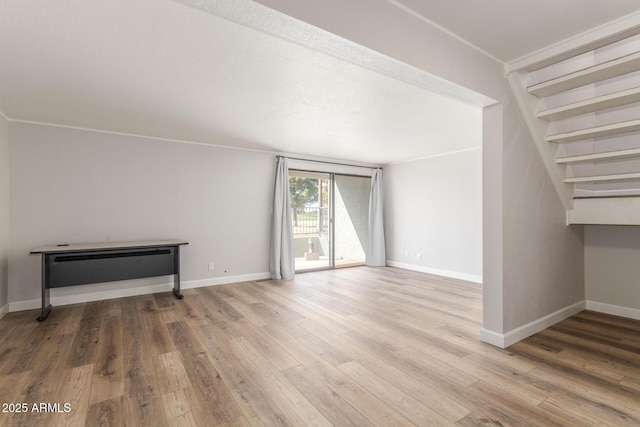 unfurnished living room featuring hardwood / wood-style floors and crown molding