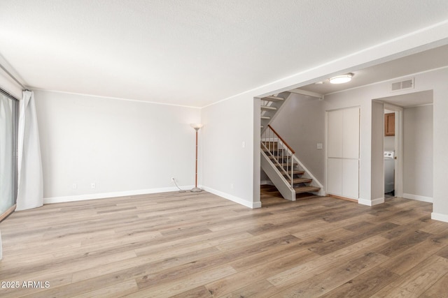 spare room with washer / dryer and hardwood / wood-style floors