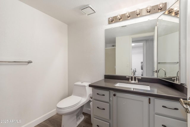 bathroom with toilet, wood-type flooring, and vanity