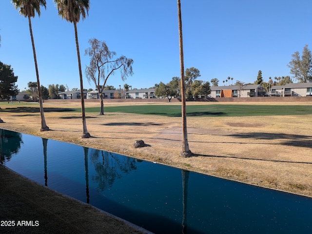 view of property's community with a lawn and a water view