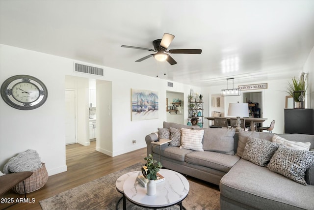 living room featuring ceiling fan and dark hardwood / wood-style floors